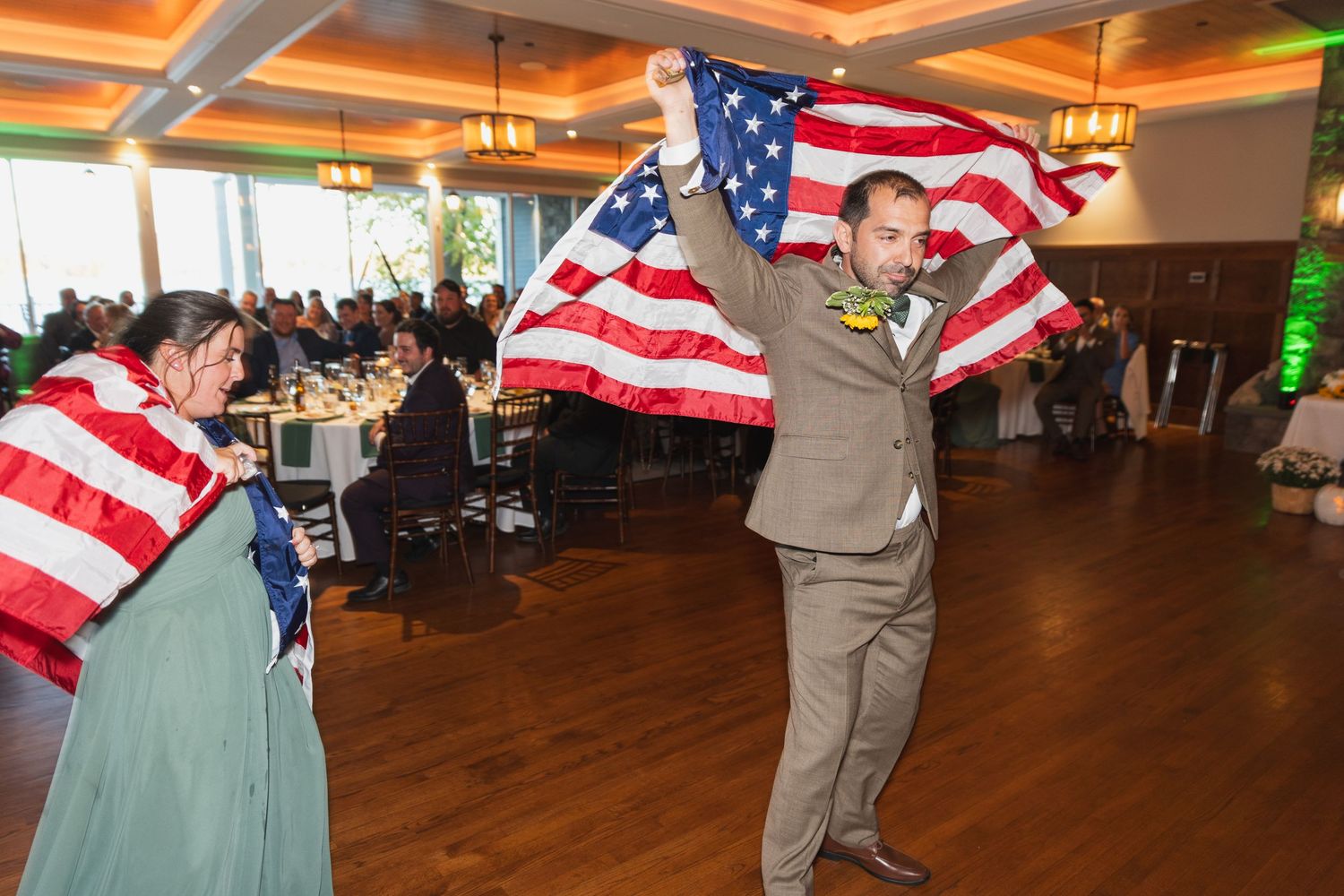 Wedding reception dance floor with American flag decor and warm lighting.