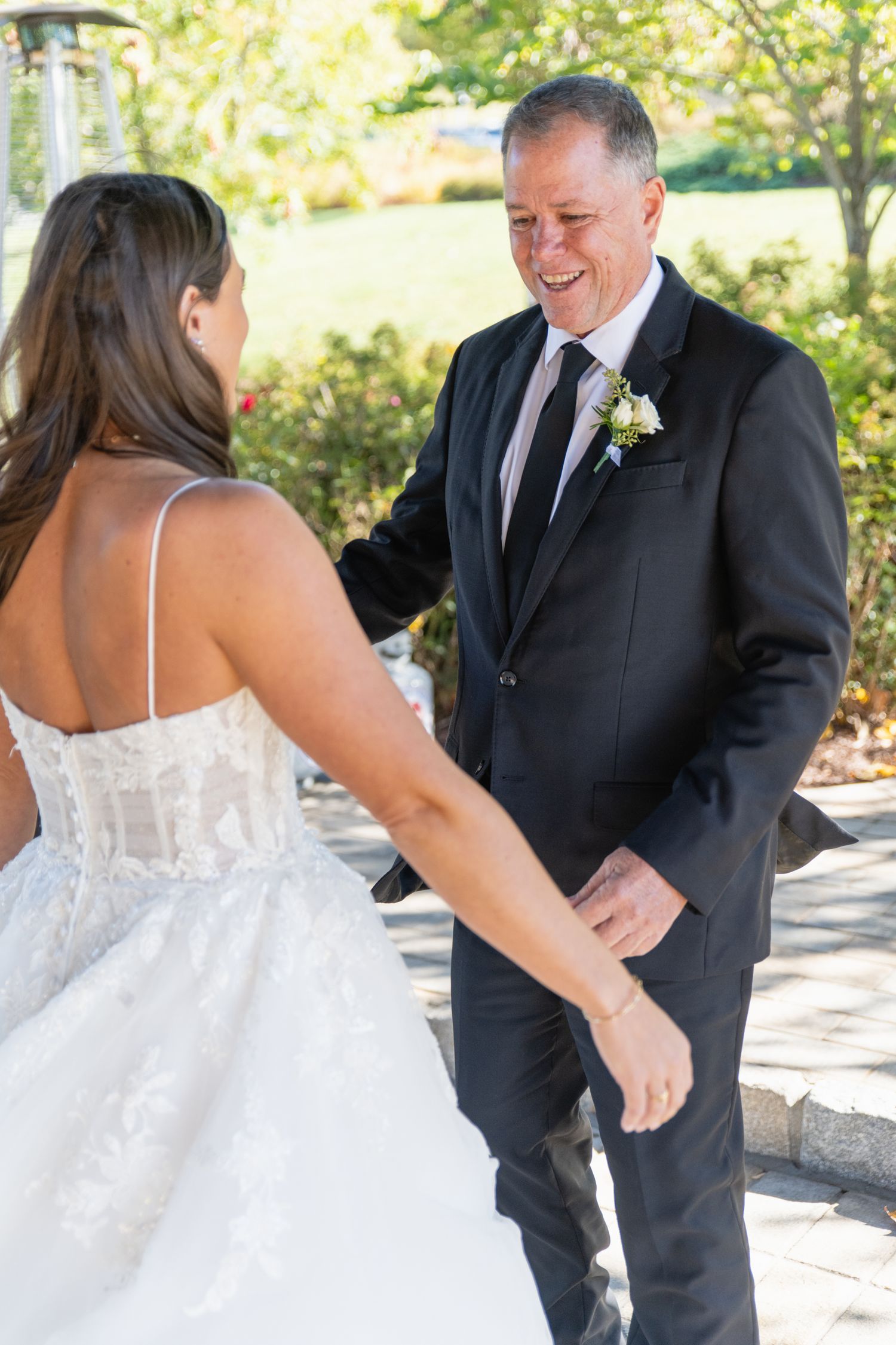 A series of candid wedding photos showing an emotional first look between a bride in white and someone in a black suit.