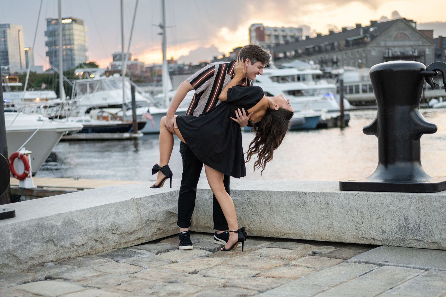 Urban engagement session at sunset near a marina with casual clothing.