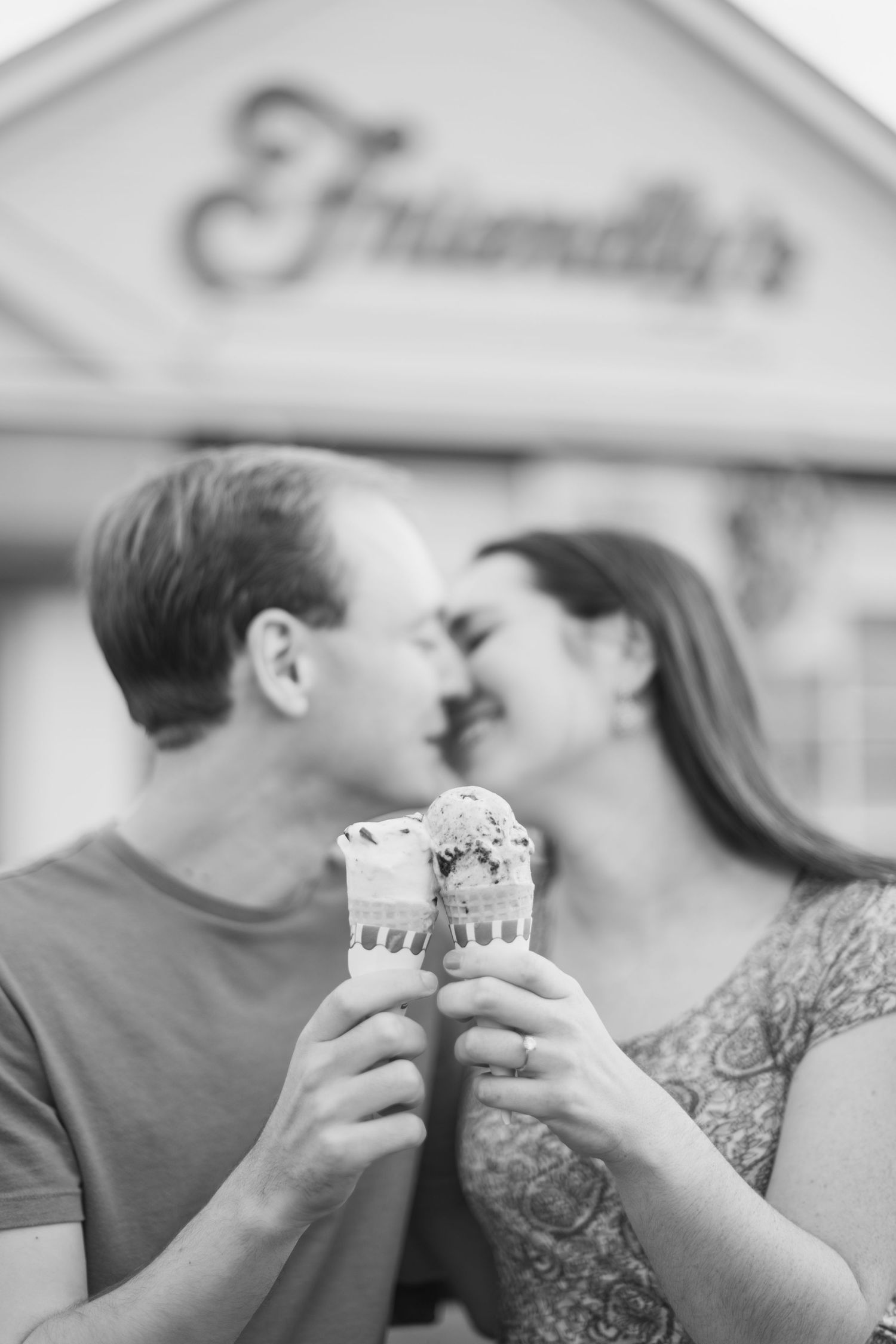 Black and white photo of couple sharing ice cream cones outside Friendly's restaurant.