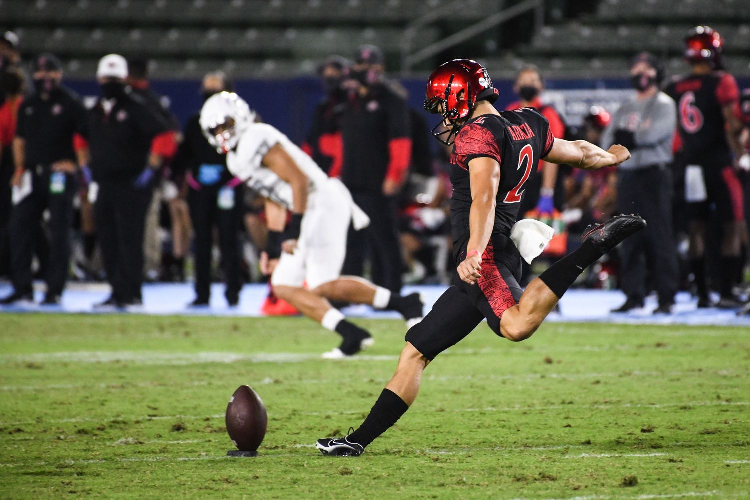 A San Diego State football player kicks the ball during a night game at the stadium.