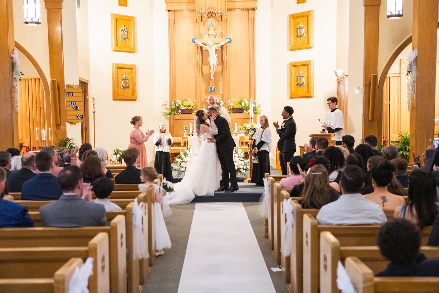 Traditional church wedding ceremony with guests seated in wooden pews.