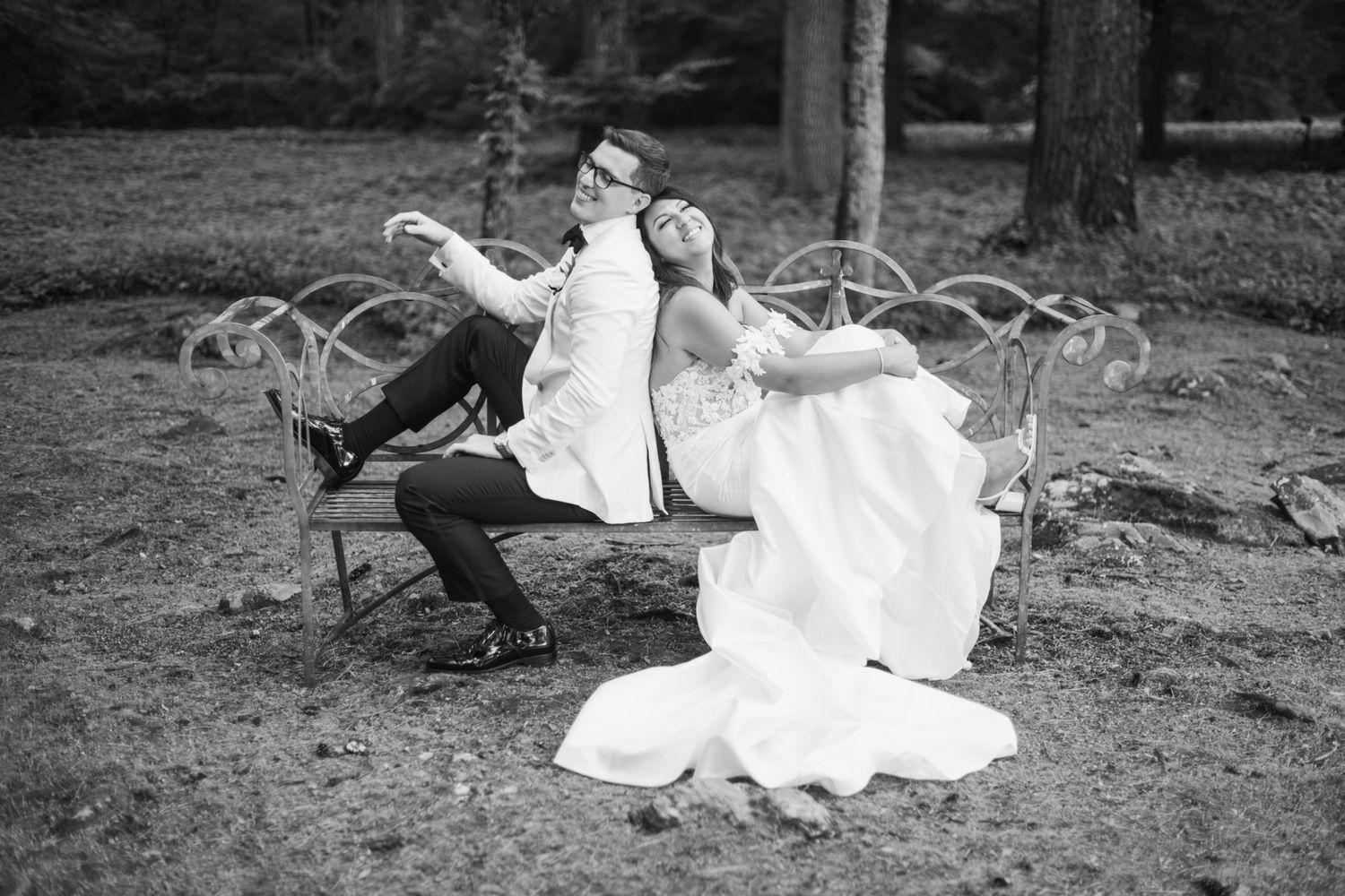 Black and white wedding portraits capturing romantic moments between a bride and groom in nature.