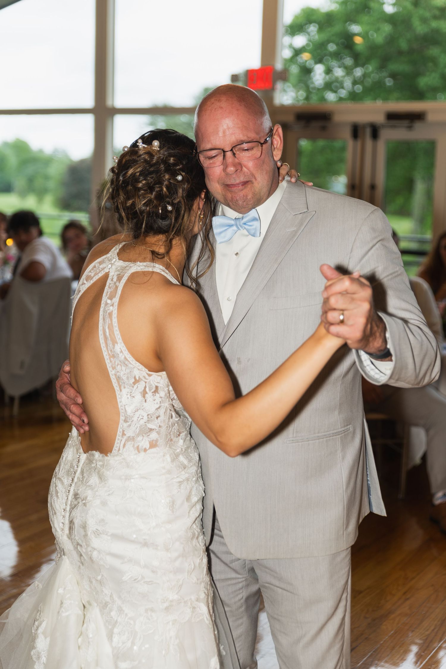 Father-daughter dance captured in intimate moments on wooden dance floor.