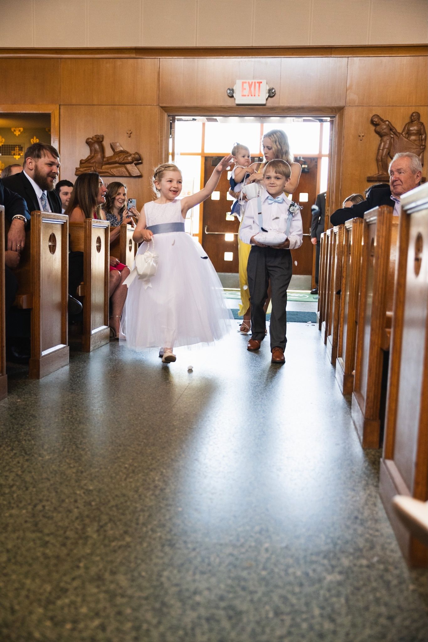 Wedding party celebrates in a church hallway with joyful gestures and movements captured in sequence.