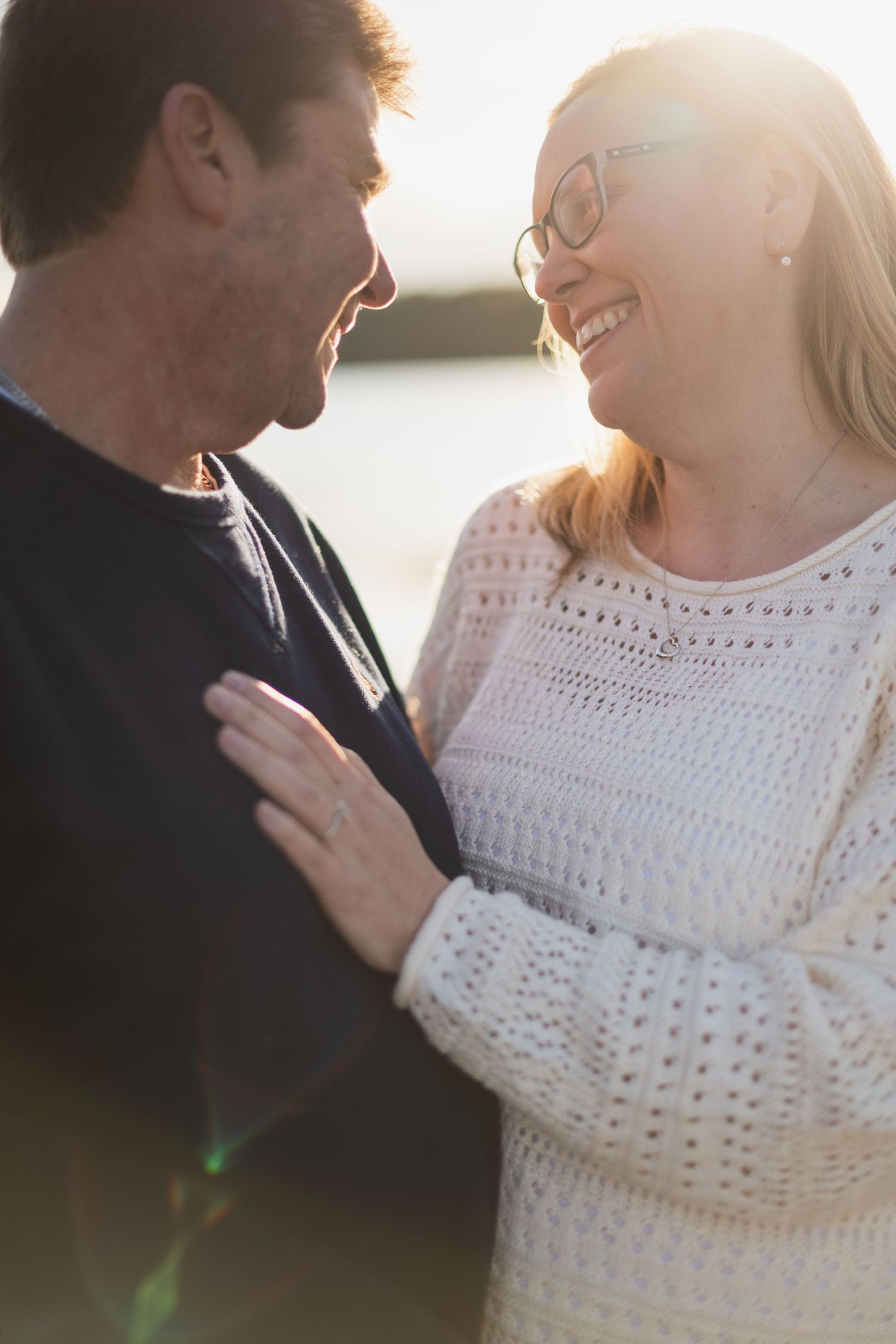 Romantic golden hour portraits showing tender moments in white knit sweater.