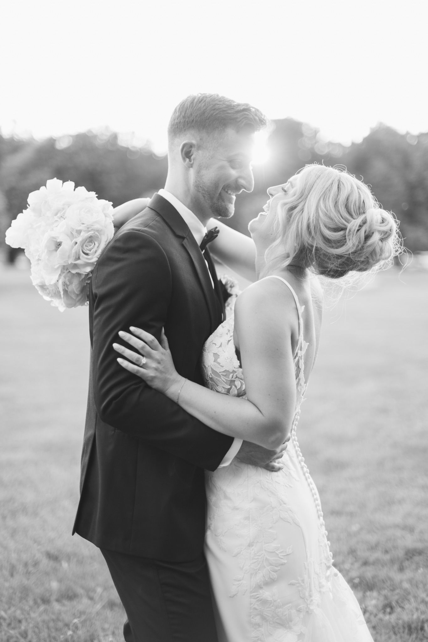 Black and white romantic wedding portraits captured in sunlit outdoor setting.