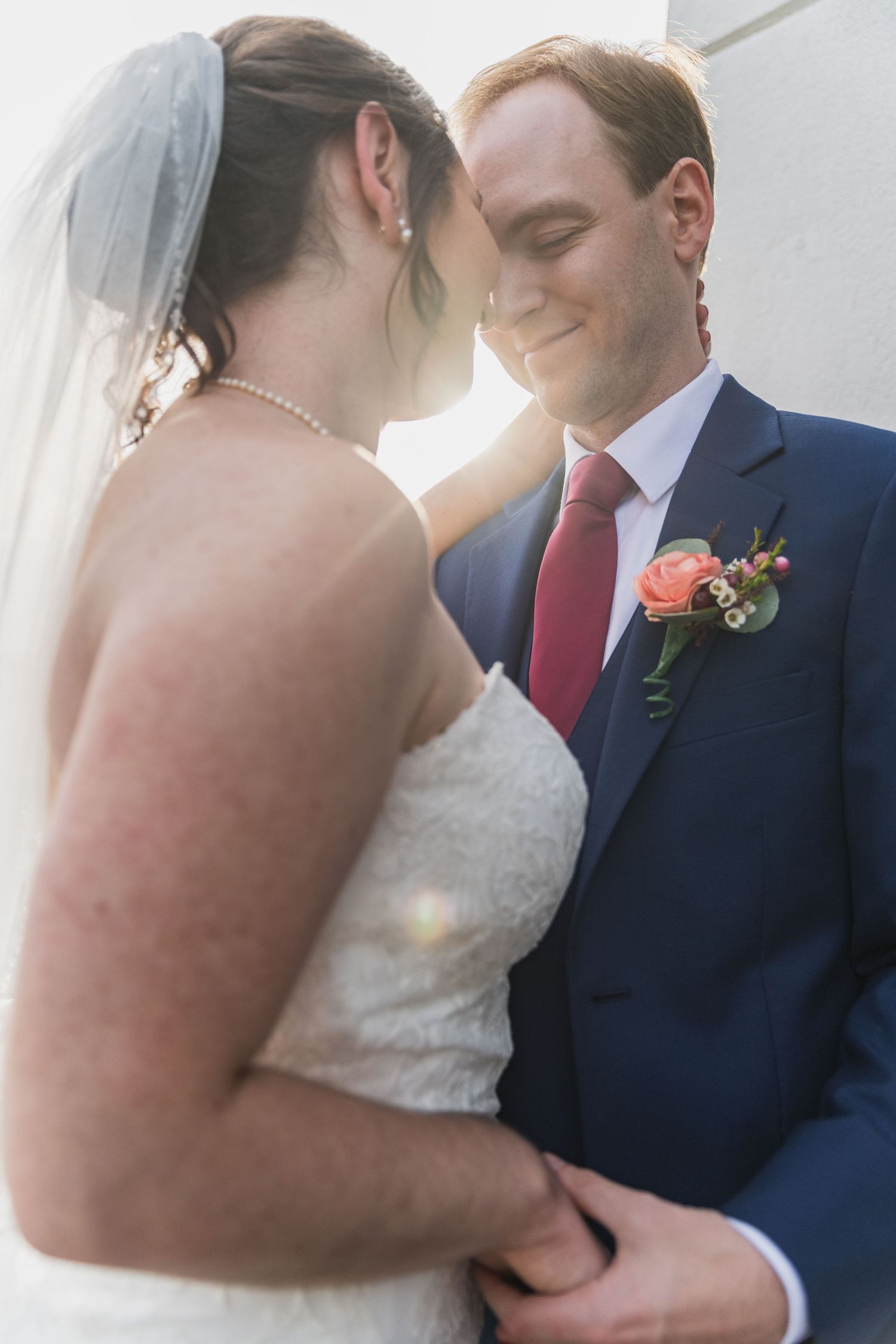 Intimate wedding moment captured in soft light as couple shares a tender moment.