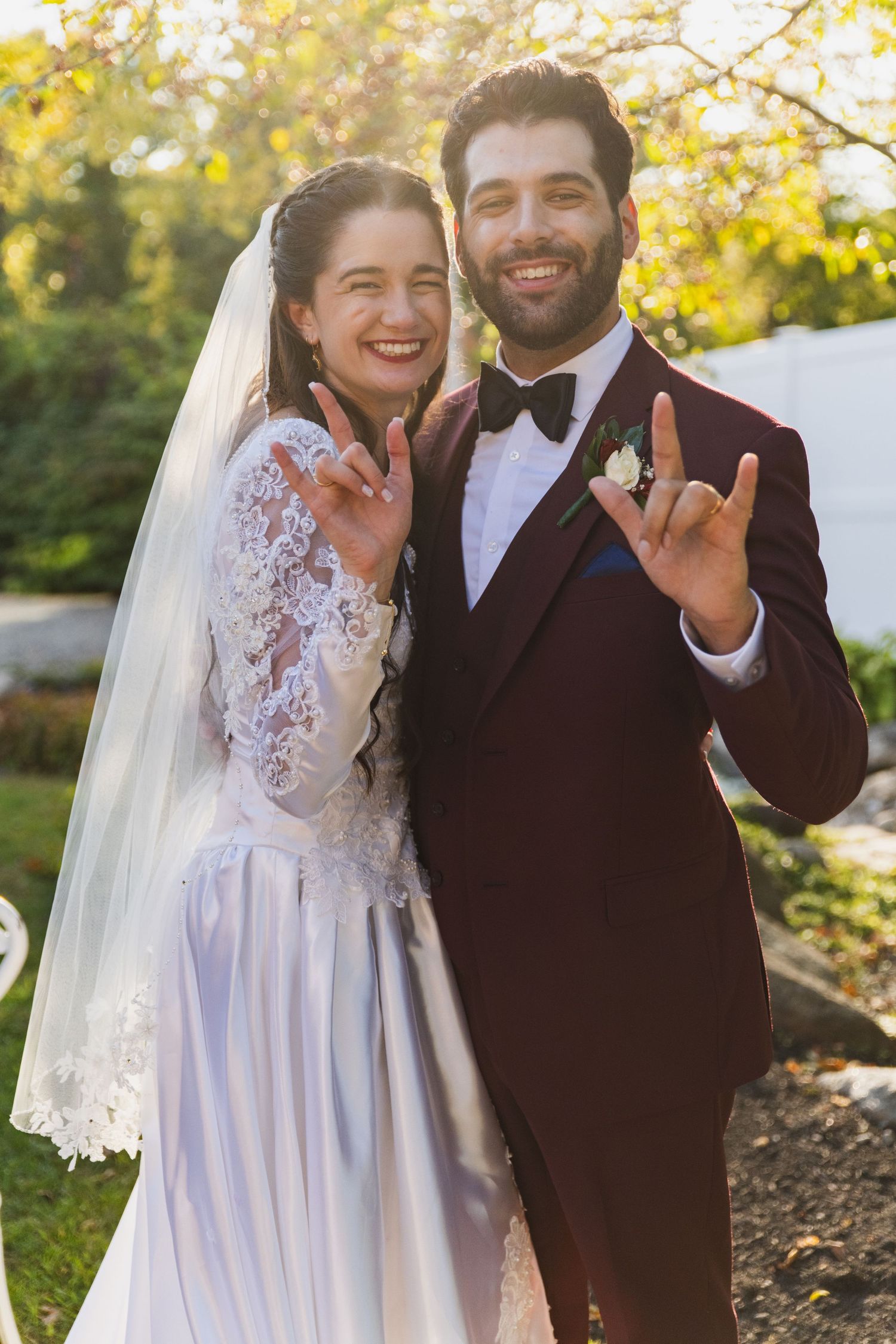 Joyful outdoor wedding portraits showing a couple in white dress and dark suit against autumn foliage.