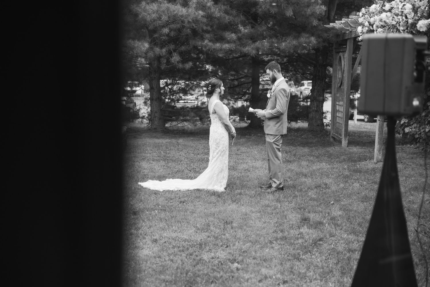 Black and white photo of couple dancing outdoors during wedding celebration.