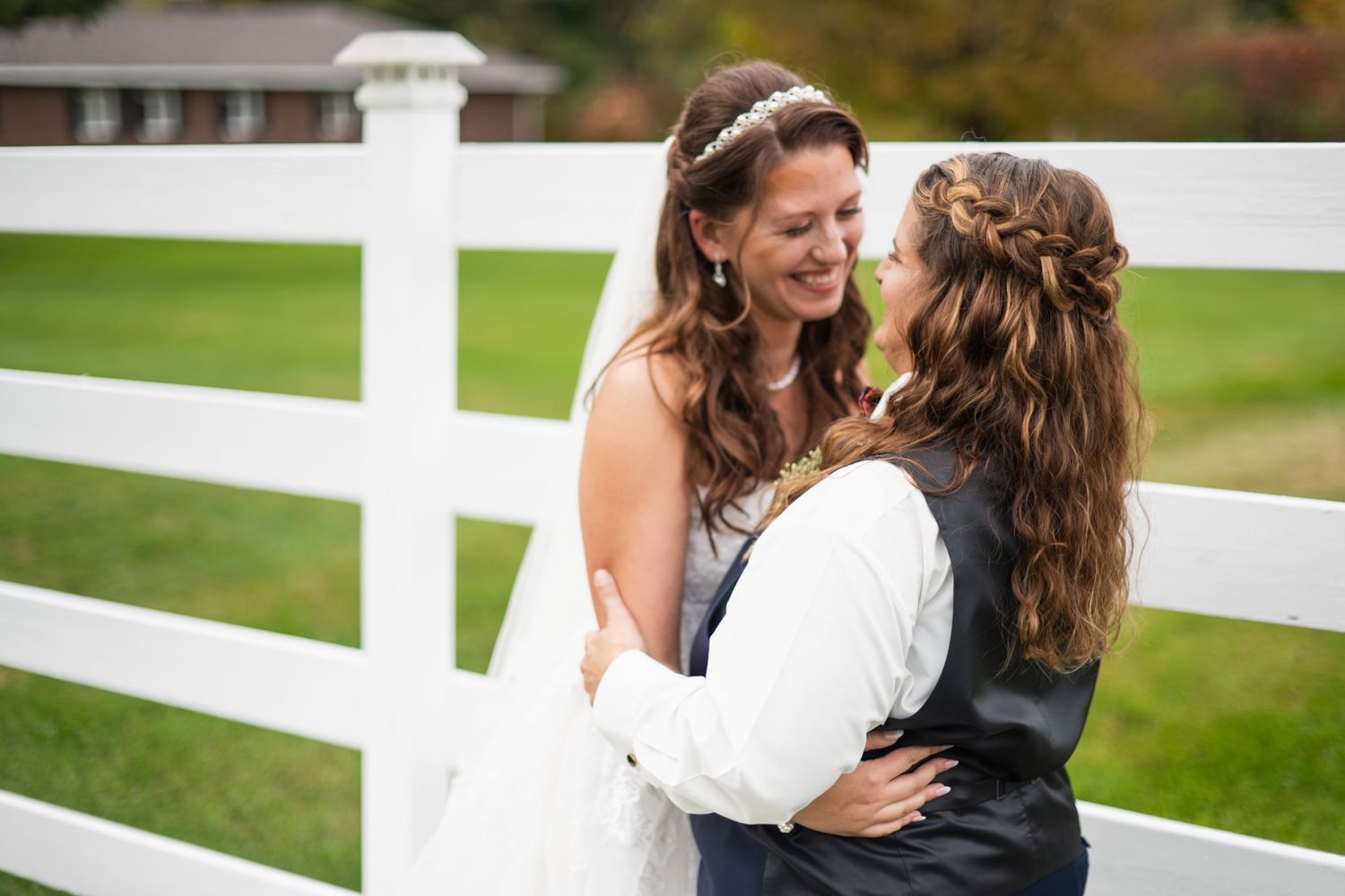 A romantic moment between a couple against a white fence background.