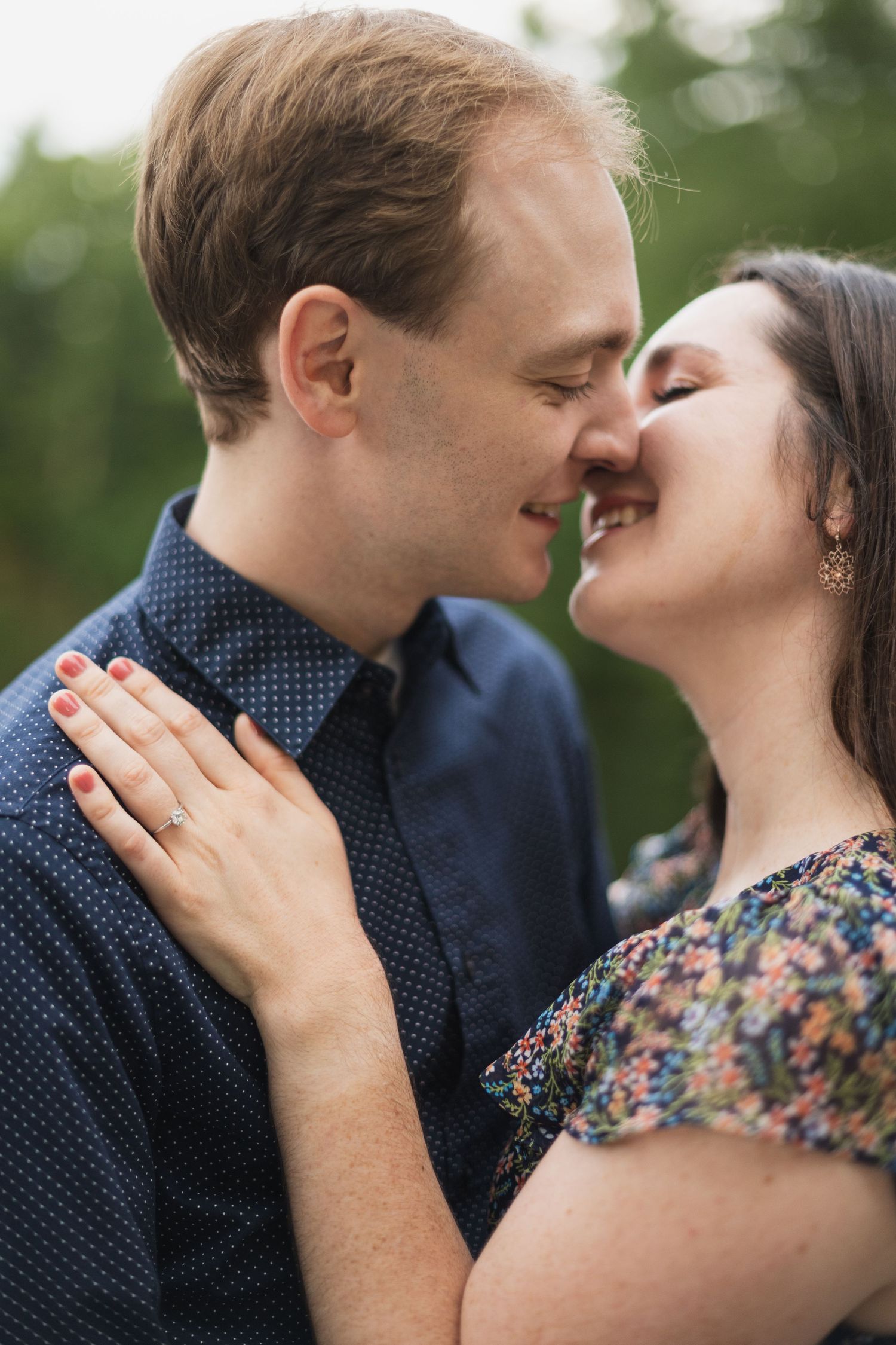 A tender moment captured between two people in close embrace outdoors.