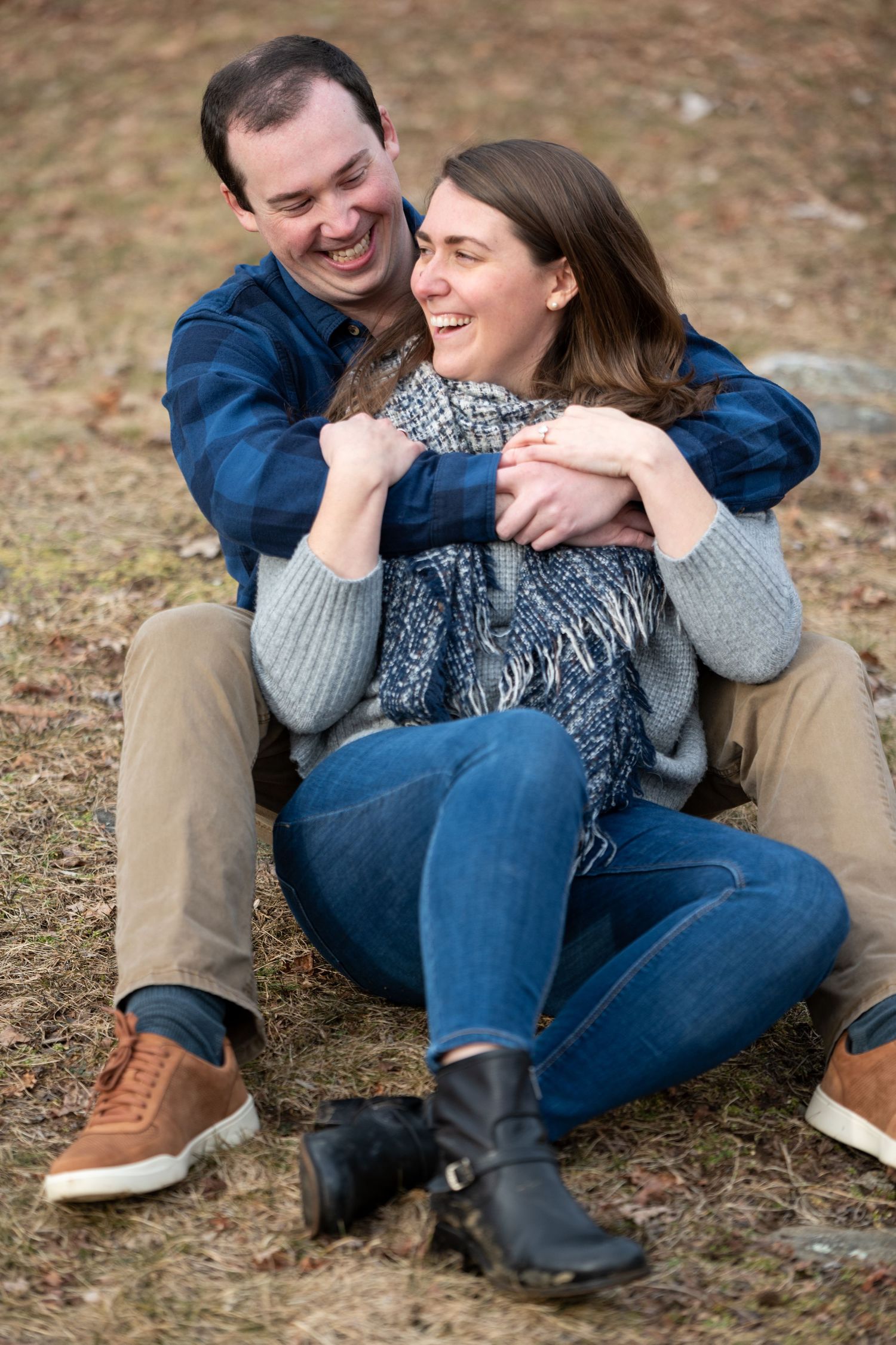 Couple shares affectionate moments while sitting together on autumn ground.