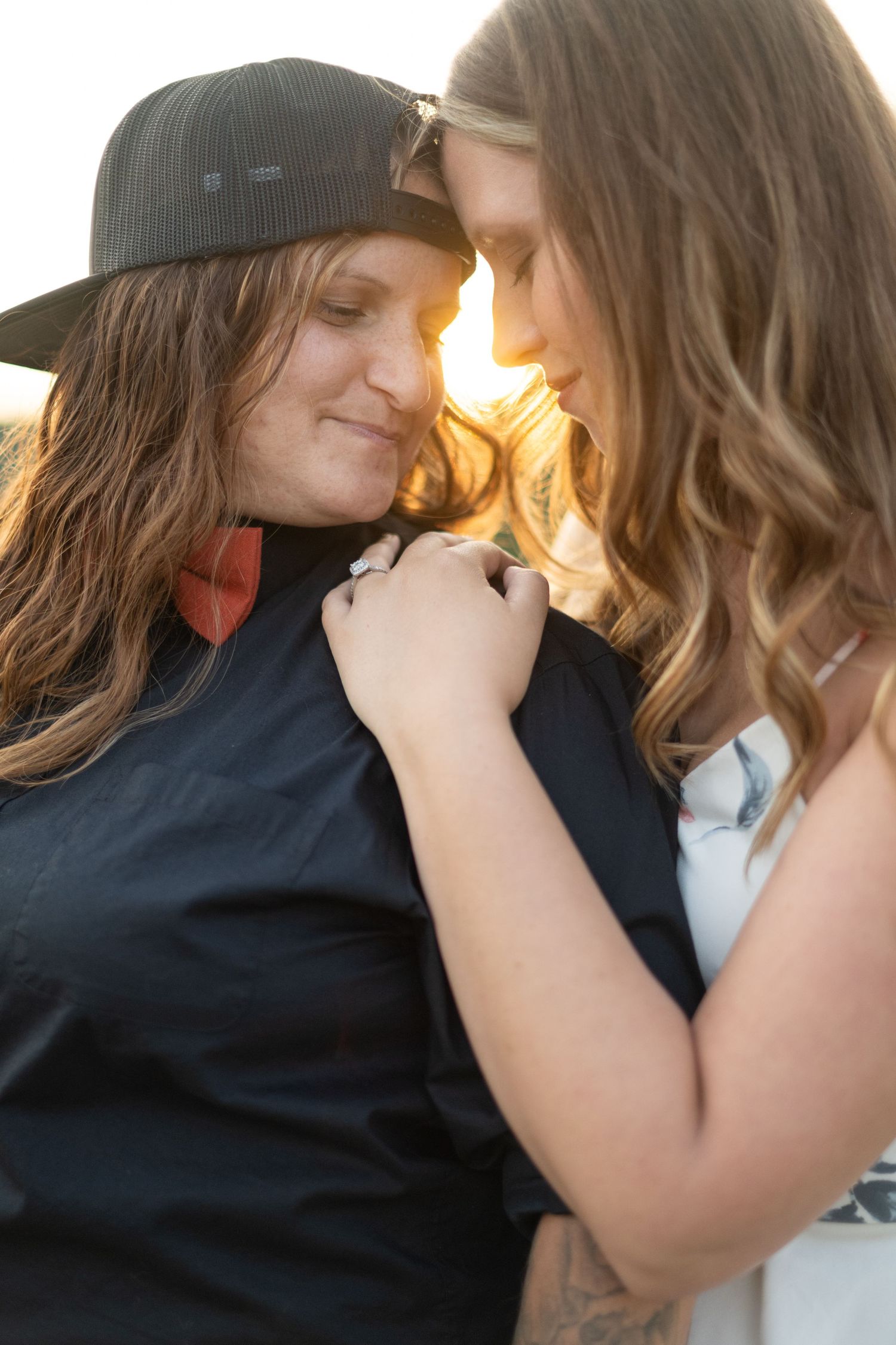A tender sunset moment between two people with warm golden light in the background.