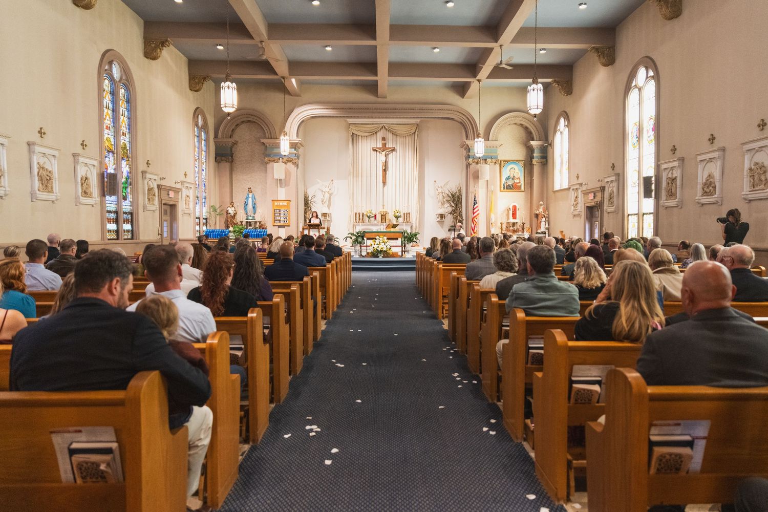 Interior view of church sanctuary with wooden pews during wedding ceremony.