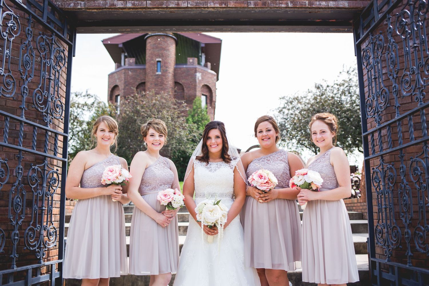 Bride with bridesmaids in an outdoor wedding formal.