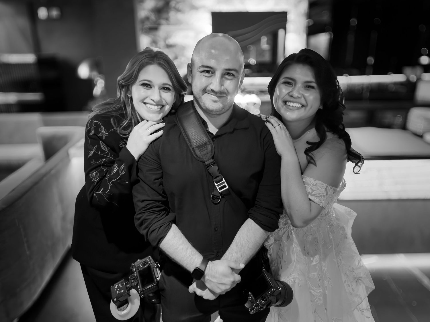 Wedding photographer posing with brides.