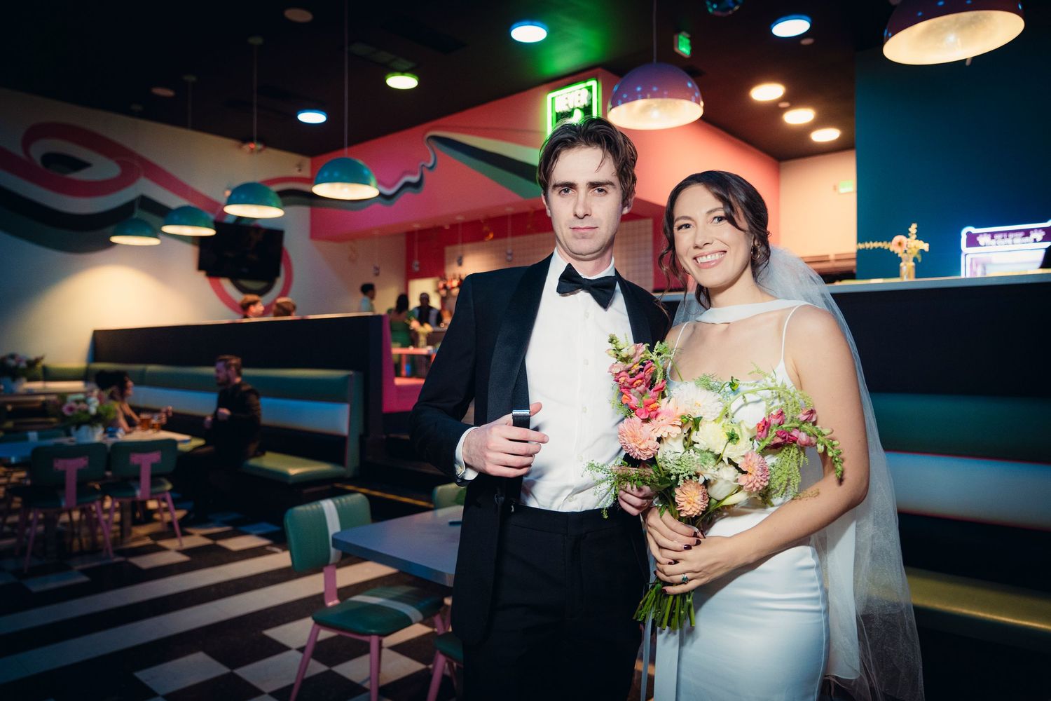 Portrait of bride and groom in a bowling alley reception party.