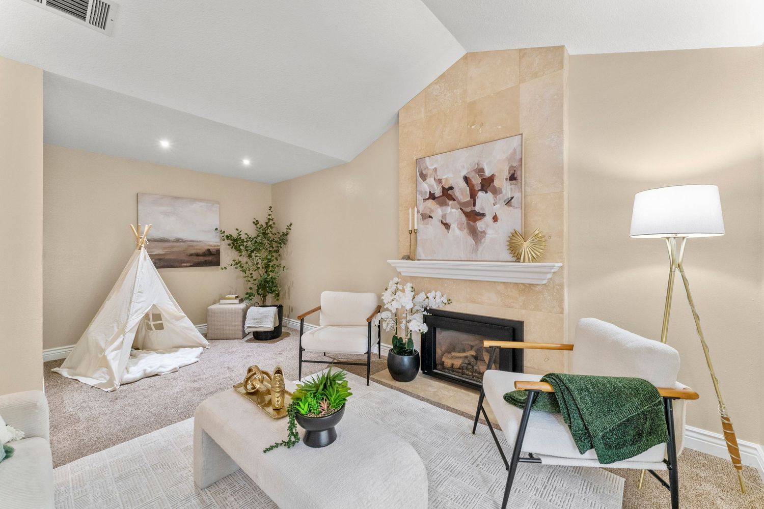 Vaulted living room with tile fireplace, white seating, neutral carpet, recessed lighting, and decorative childrens play tent.