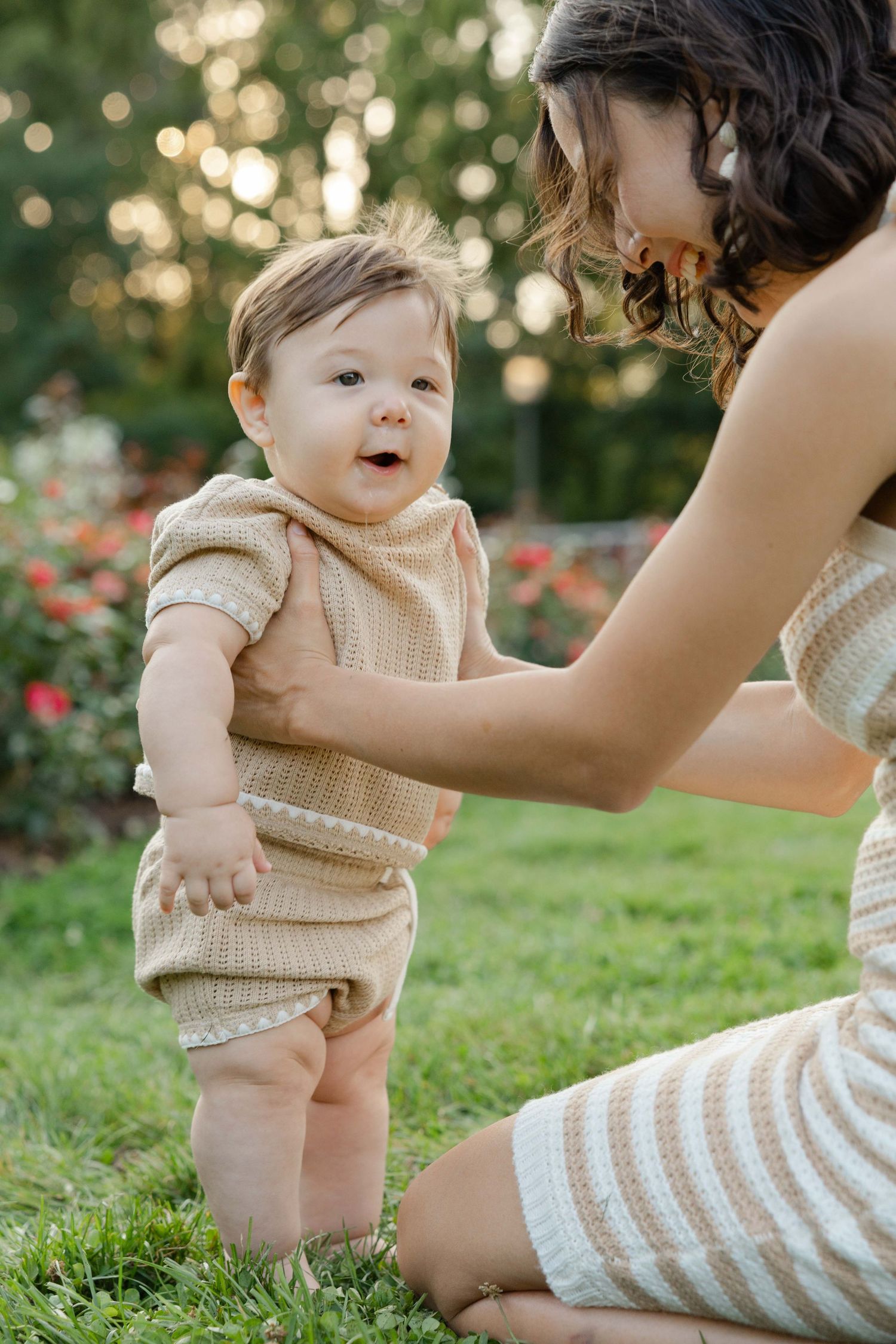 baby standing holding mom during family session in Apple Valley MN