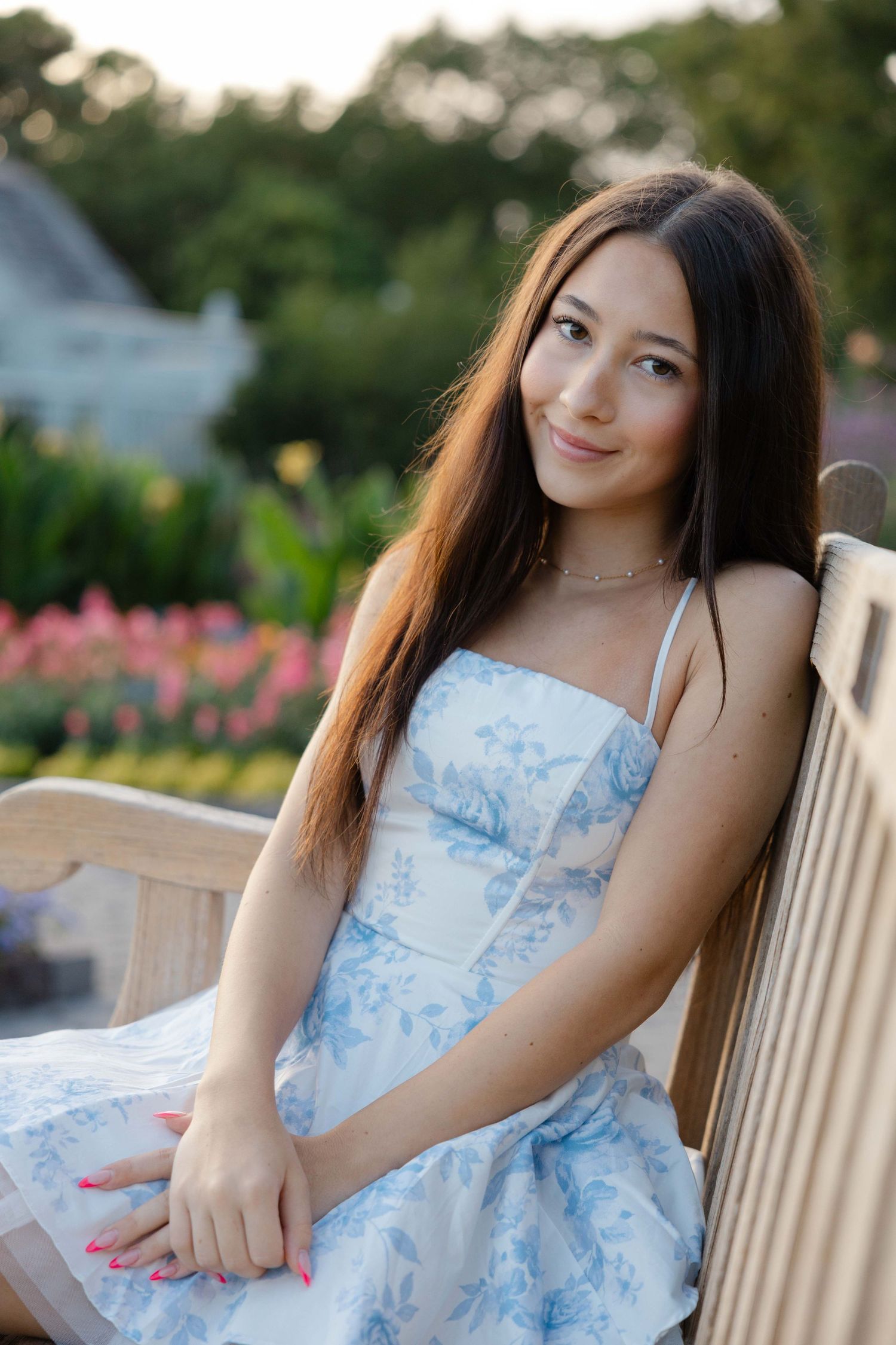 high school senior portrait of a girl in a flower garden, smiling, wearing a beautiful dress