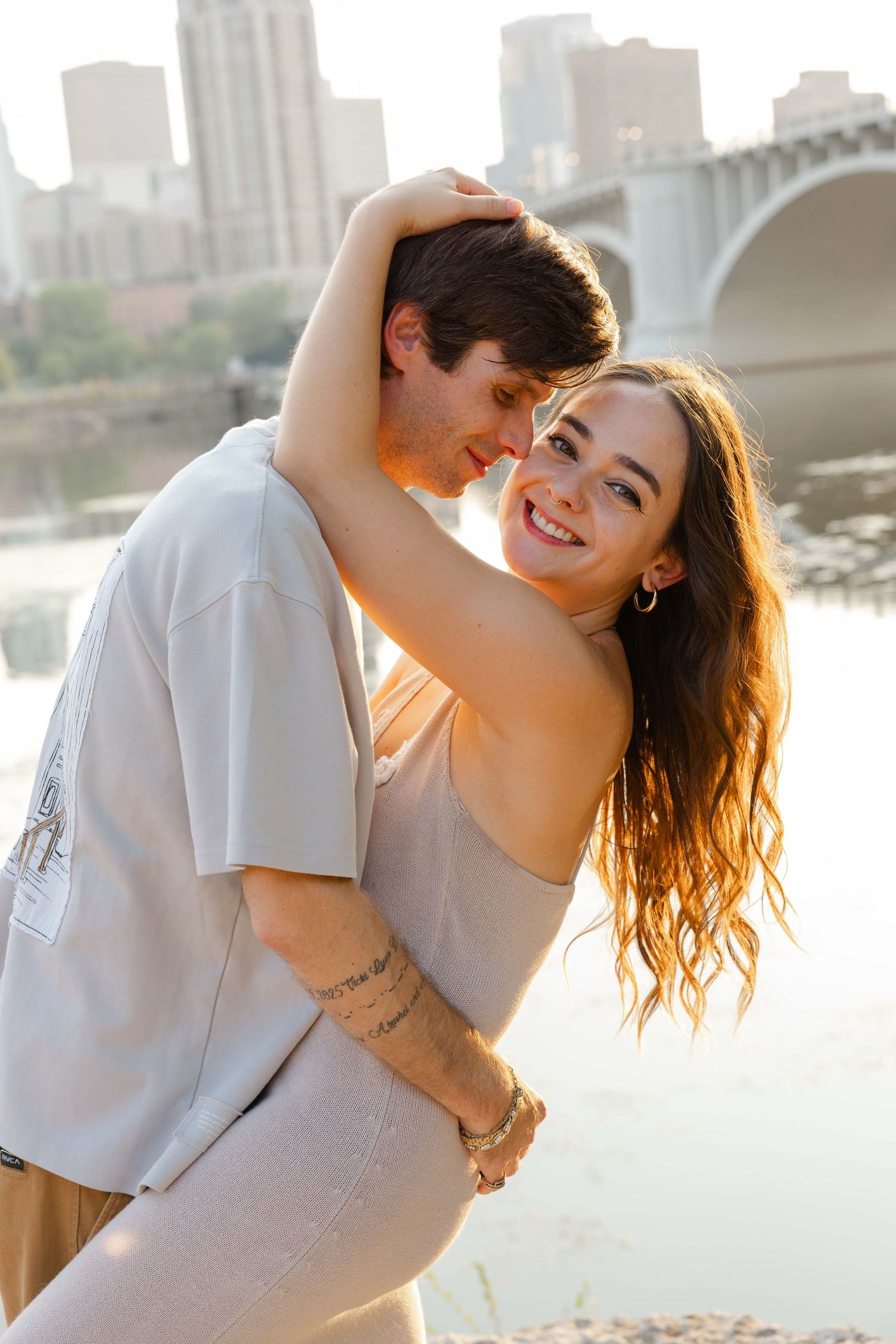 couples session in Minneapolis by Misissipi river, golden light, kissing, happy