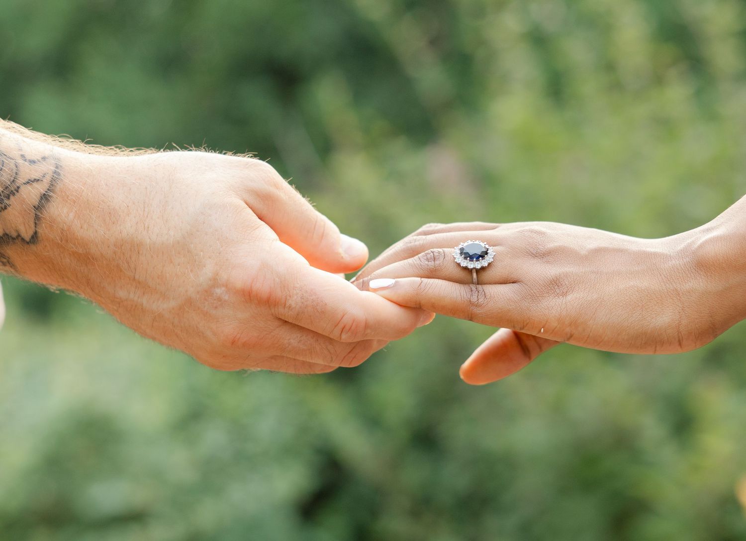 close up photo of hands of a couple who got engaged, the photo shows the ring