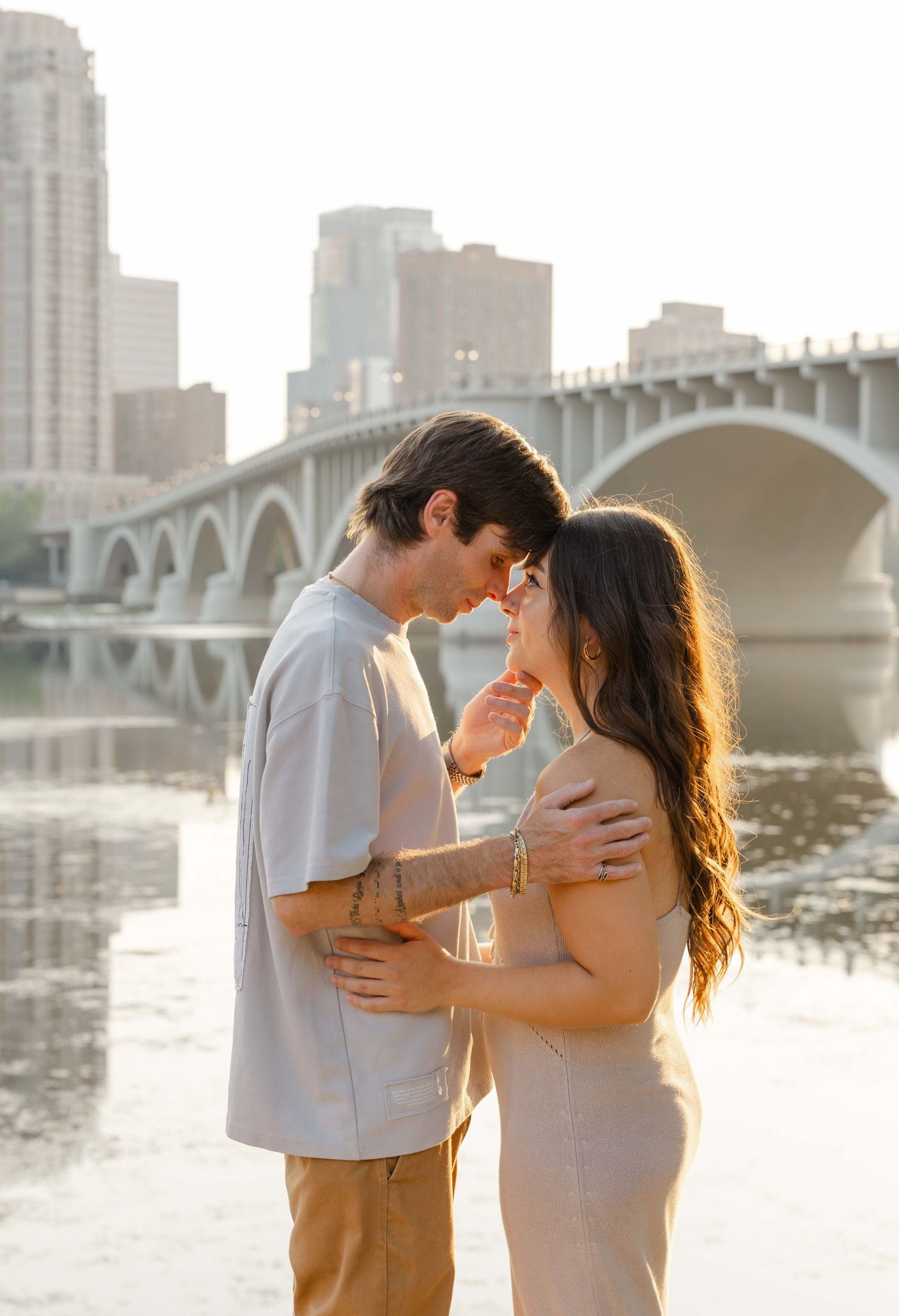 couples session in Minneapolis by Missisipi river, golden light, kissing, love story