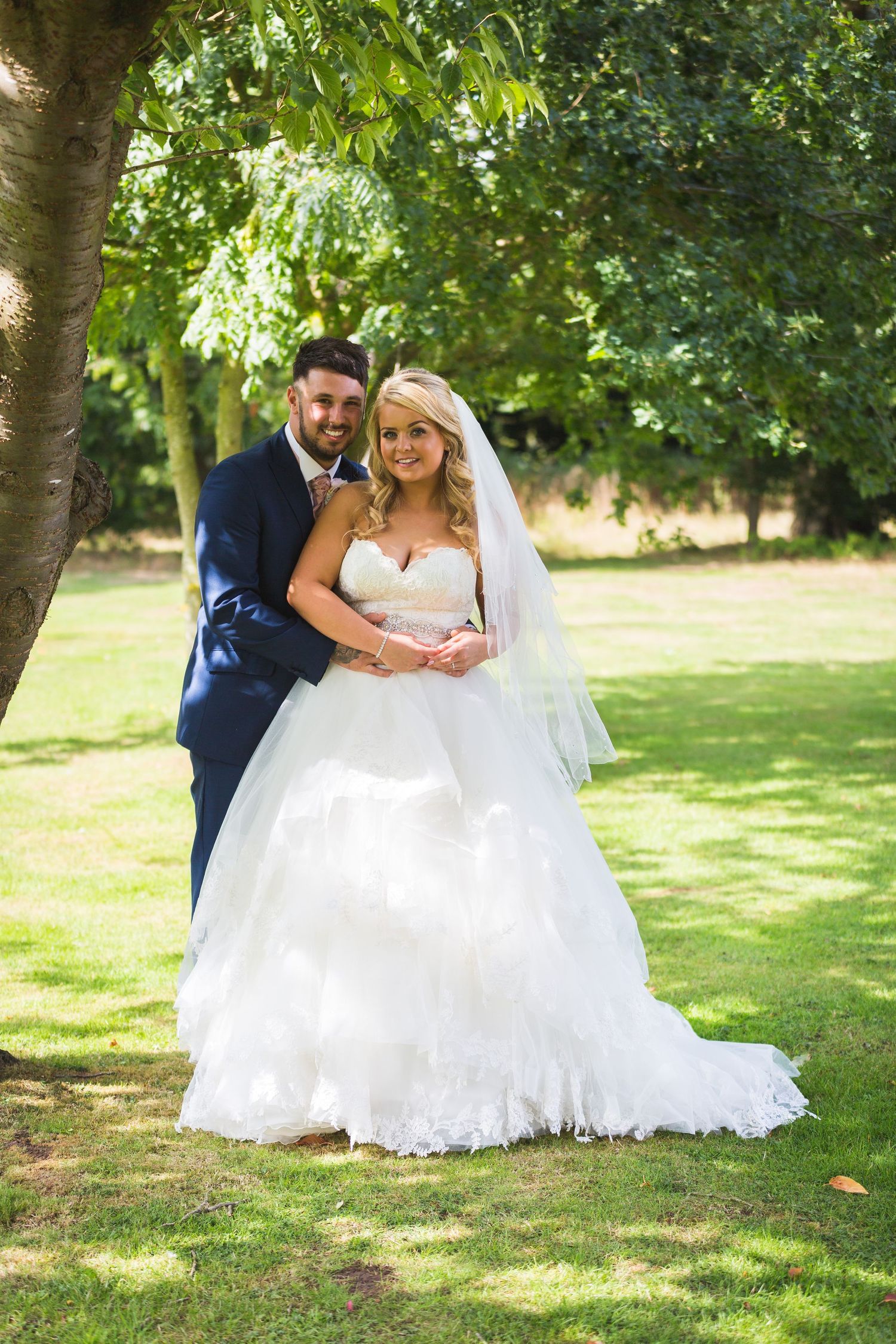 Newlyweds pose in garden setting on their wedding day.