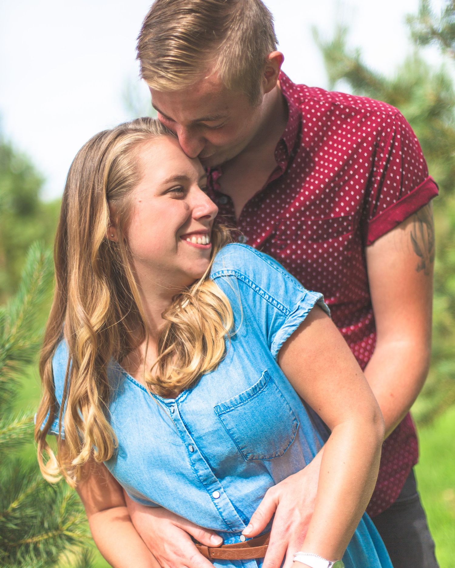 A romantic countryside moment between a couple in coordinating blue and red outfits.