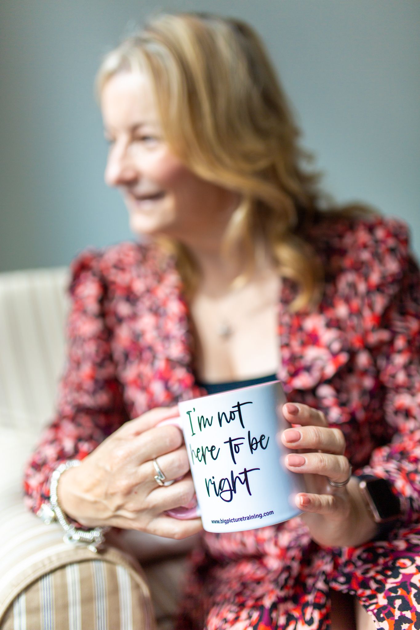 female professional at work looking at camera smiling at work with a passive aggressive mug