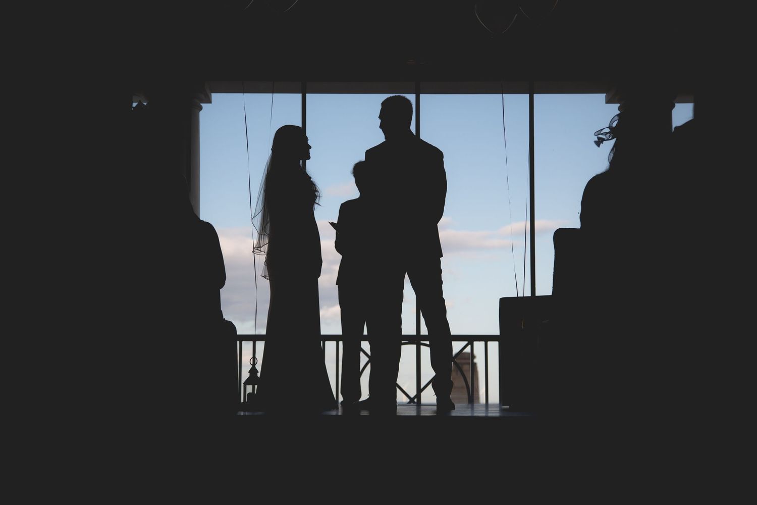 Silhouetted figures stand against a bright window creating a dramatic backlit effect in different poses.