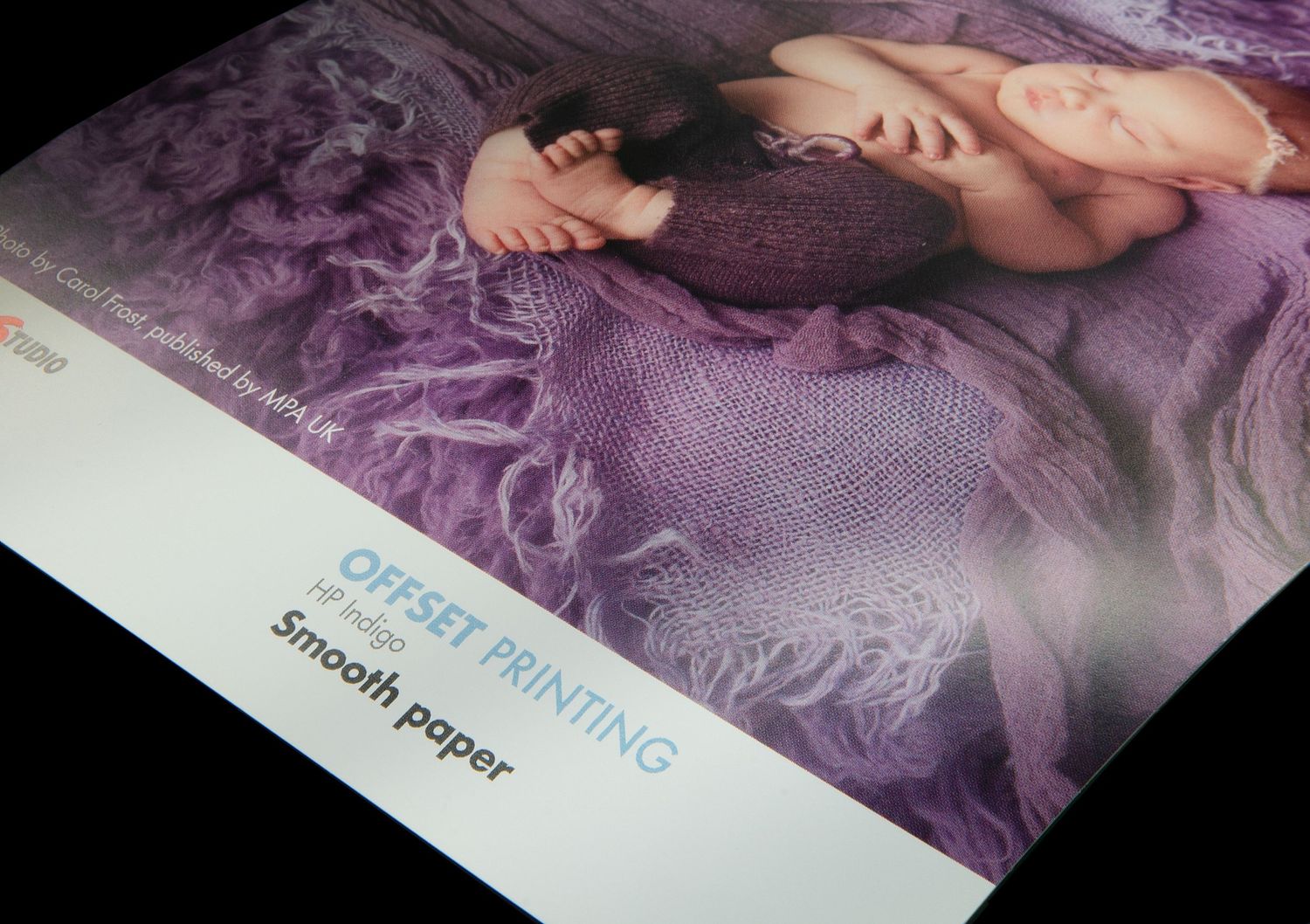 Close-up view of a photography print sample showcasing smooth paper texture with purple tones in the image.