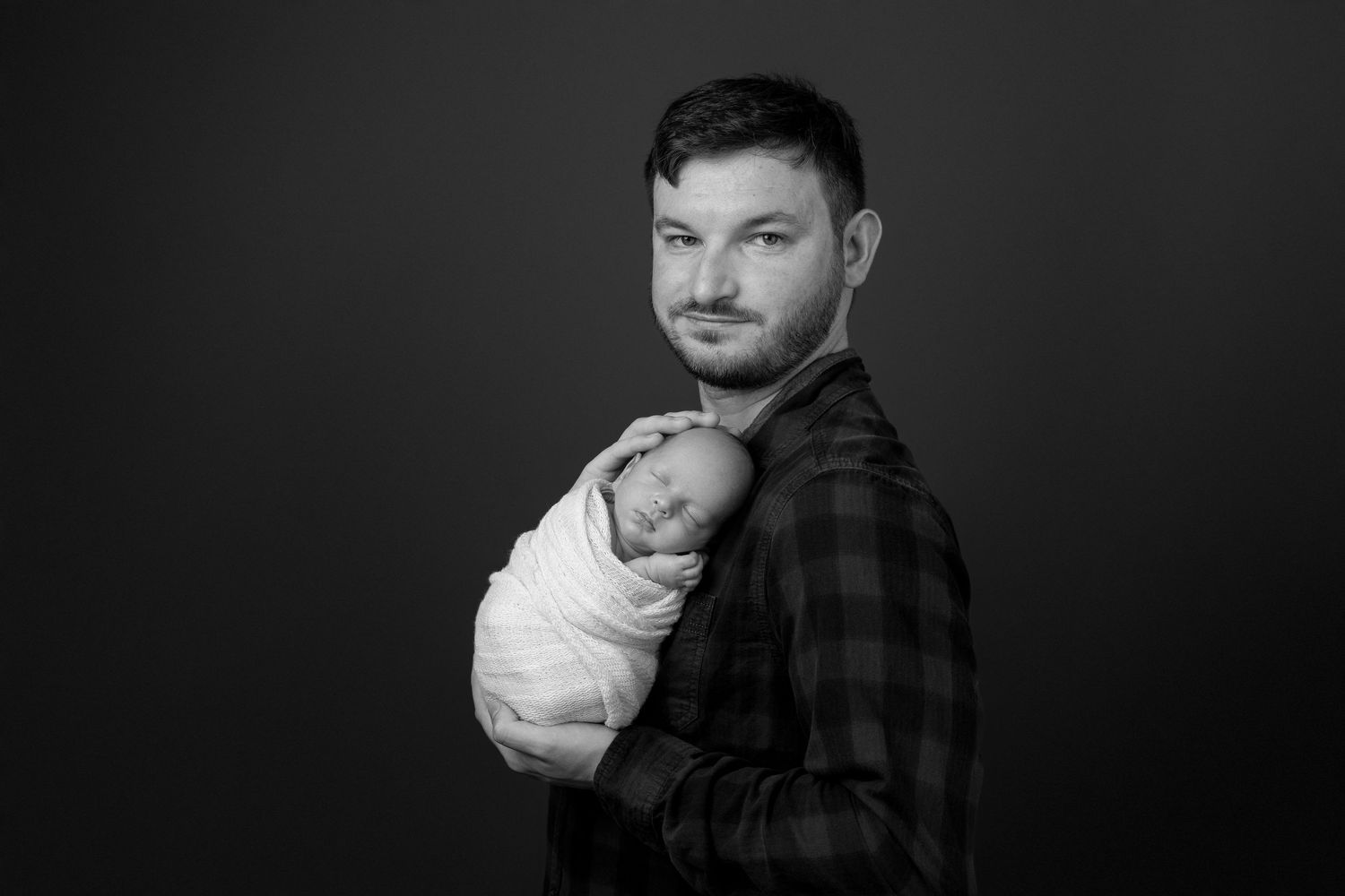 Dramatic black and white portrait series showing different expressions and poses in a shadowy setting.