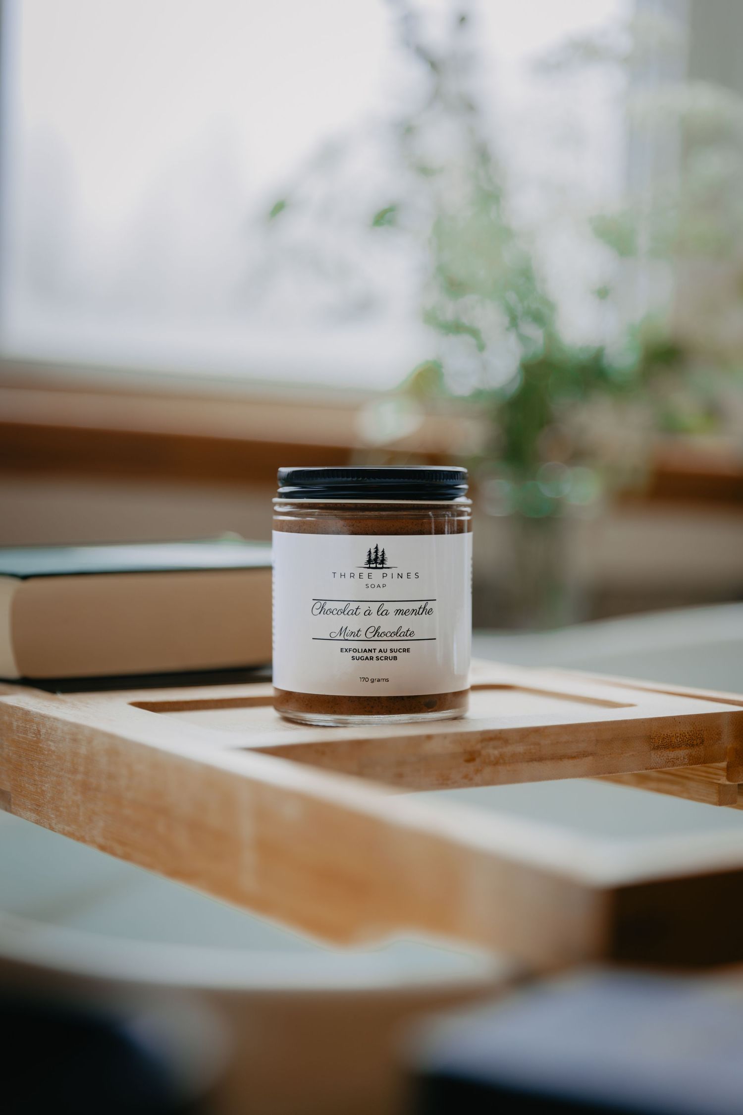 Glass jar of artisanal product positioned on wooden surface with soft natural lighting.