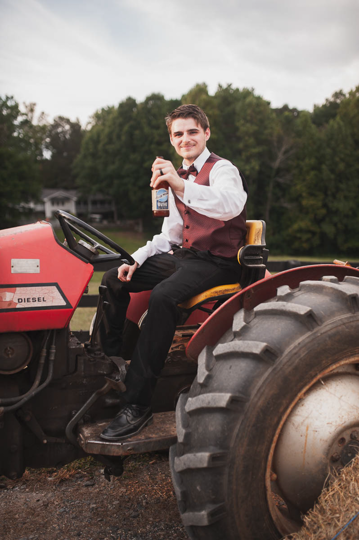 Groom portrait on tractor at Polo Club wedding in Georgia.