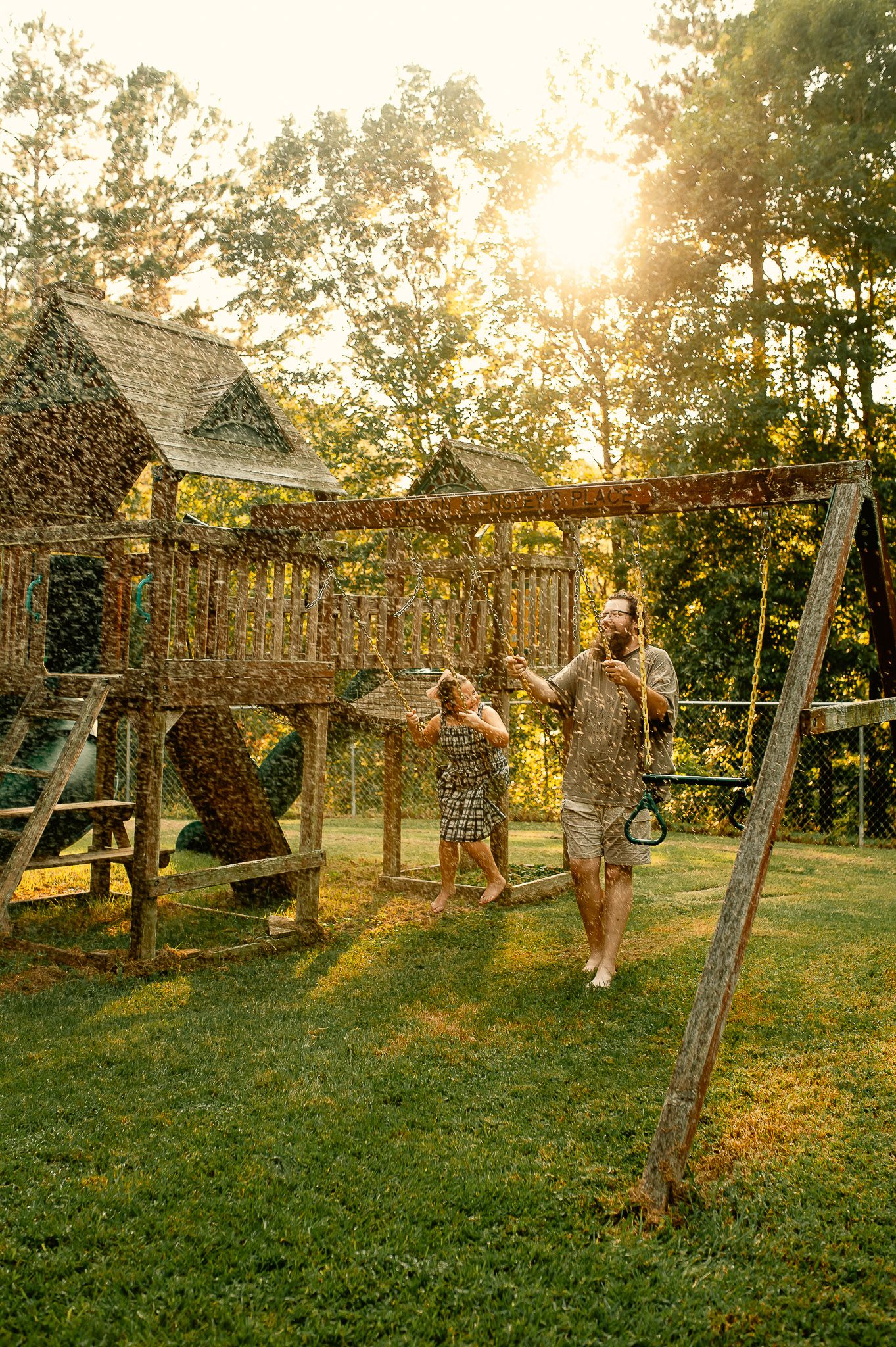Dad and daughter swinging on swingset for family photos in Cartersville, GA.