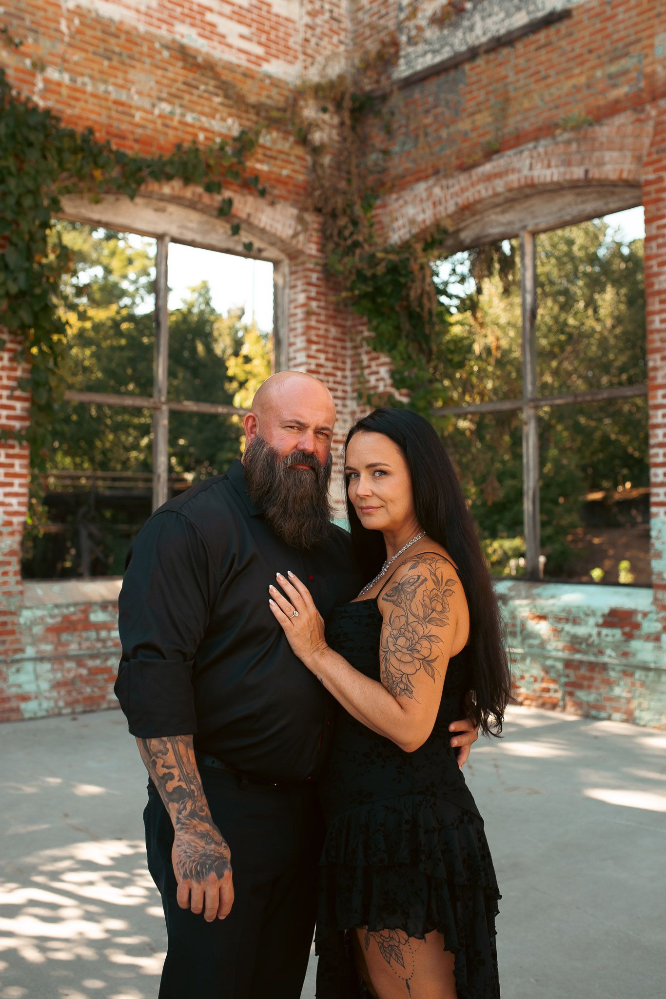 Couple posing for moody outdoor summer engagement session at Lindale Mill.