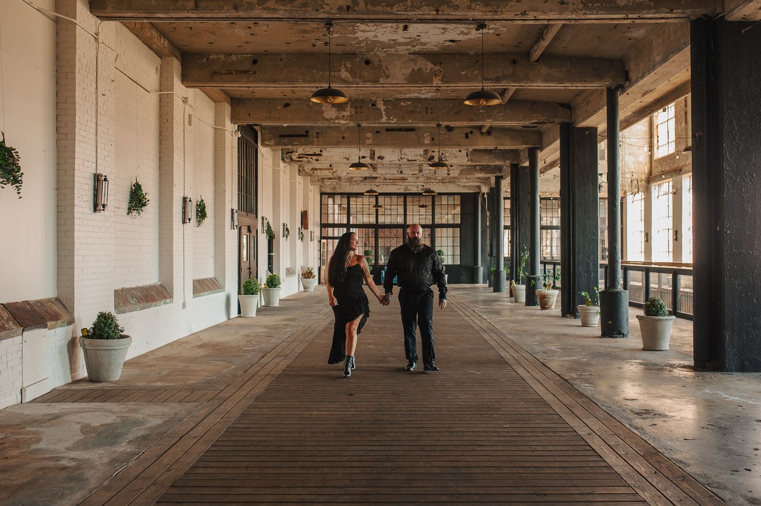 Couple walking down aisle in Lindale Mill.