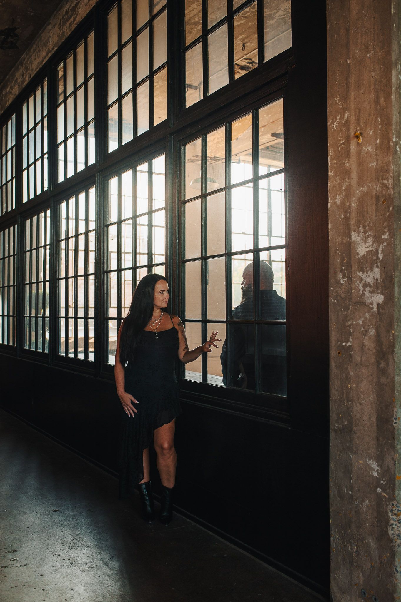 Visually interesting picture of couple on opposite sides of window in Lindale Mill.