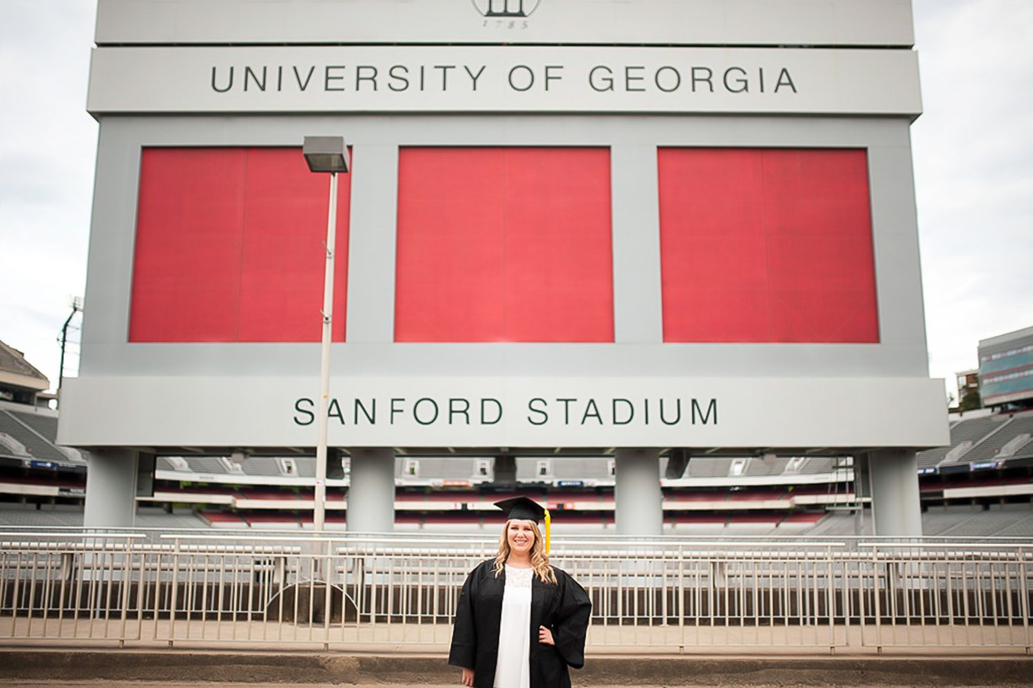 Graduation photo of girl at UGA in front of sanford stadium.
