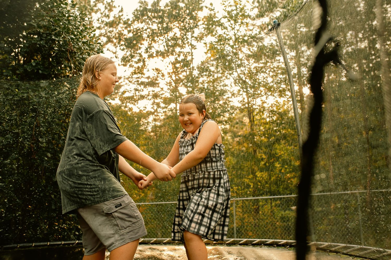 Son and daughter jumping on trampoline for family photos in Cartersville, GA.