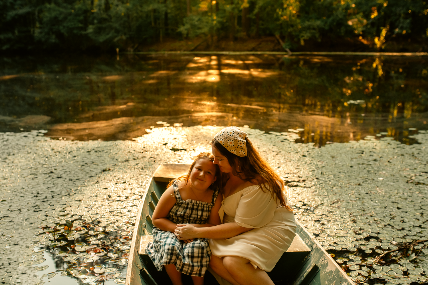 Mom and daughter snuggling in boat for family photos in Cartersville, GA.