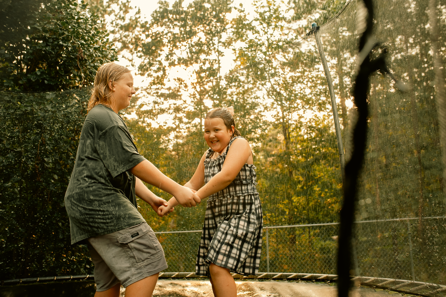 Son and daughter jumping on trampoline for family photos in Cartersville, GA.
