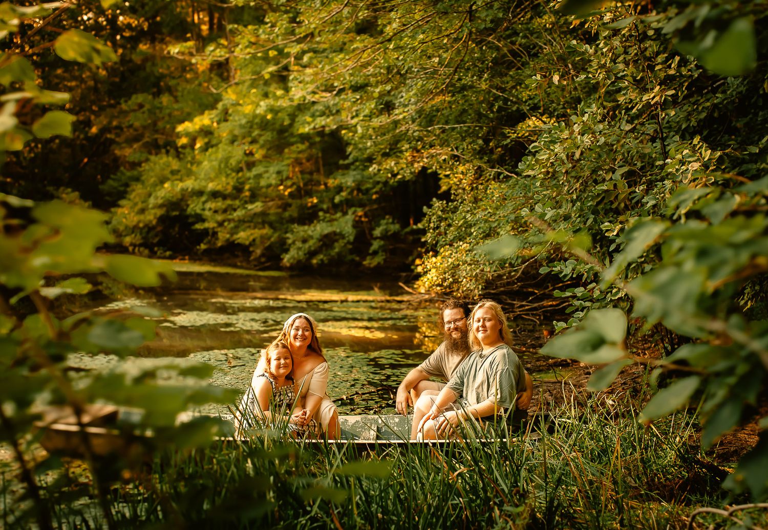 Family posing in a boat at their house for family photos in Cartersville, GA.