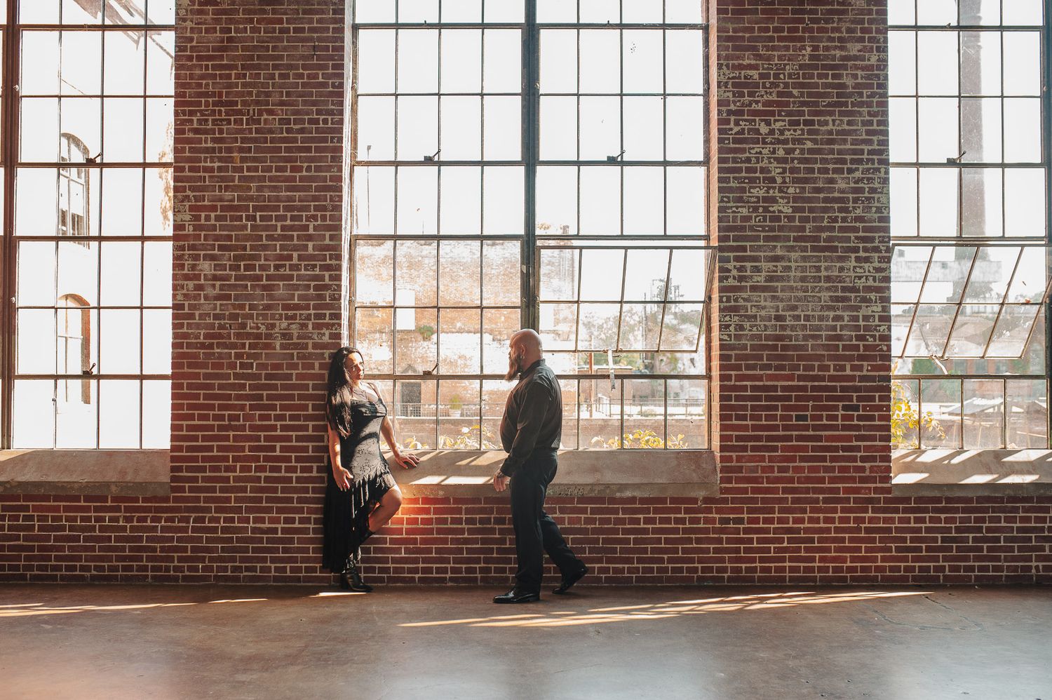 Couple posing in front of window at Lindale Mill.