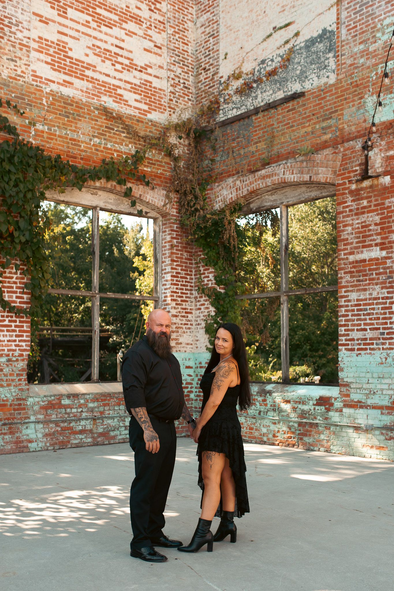 Engaged couple photoshoot holding hands in industrial ruins outside Rome, GA.