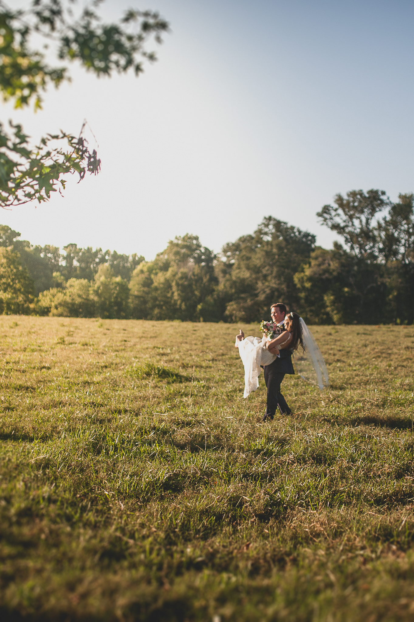 Bridal formals with groom carrying the bride in a field in Northwest Georgia.