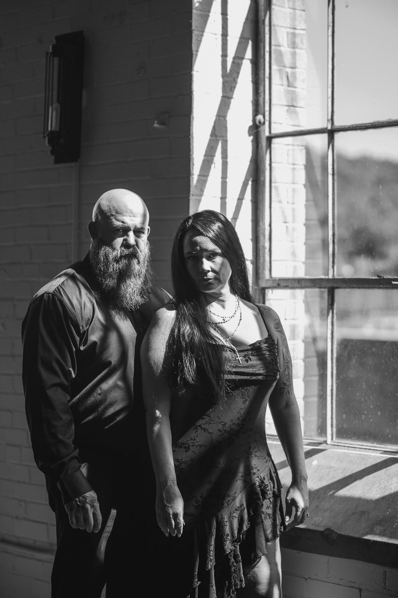 Editorial window shot of couple during engagement session at Industrial Lindale Mill in Rome, GA.