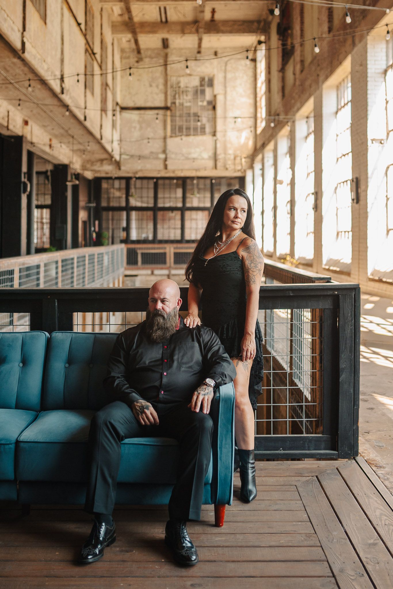 Couple sitting on couch in edgy industrial setting for a moody engagement session at the Lindale Mill in Lindale, Georgia outside of Rome.